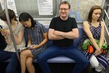 A man demonstrates 'manspreading' behaviour on the New York subway.