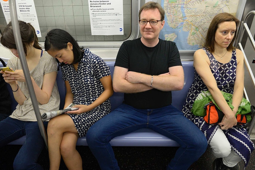A man demonstrates 'manspreading' behaviour on the New York subway.