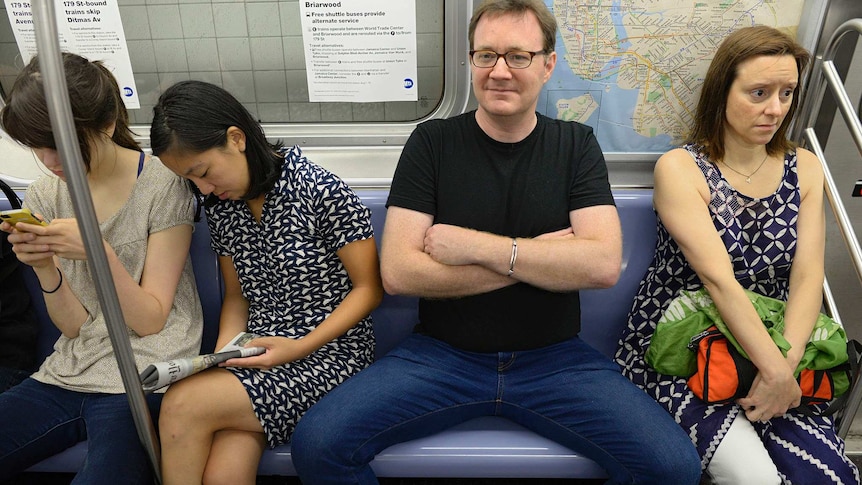 A man demonstrates 'manspreading' behaviour on the New York subway.