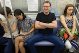 A man demonstrates 'manspreading' behaviour on the New York subway.