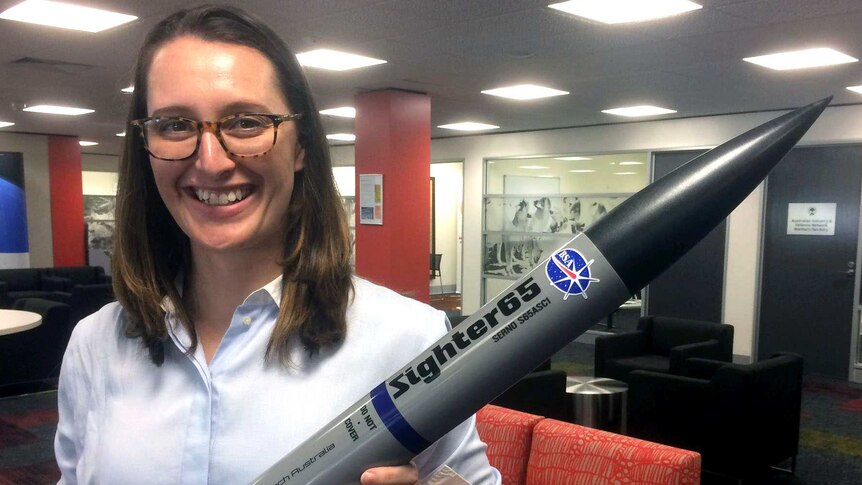 Carley Scott holds a replica of the rockets she plans to launch