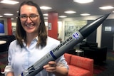 Carley Scott holds a replica of the rockets she plans to launch