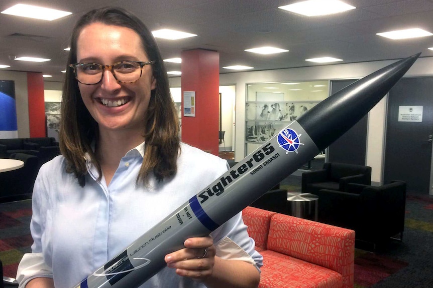 Carley Scott holds a replica of the rockets she plans to launch