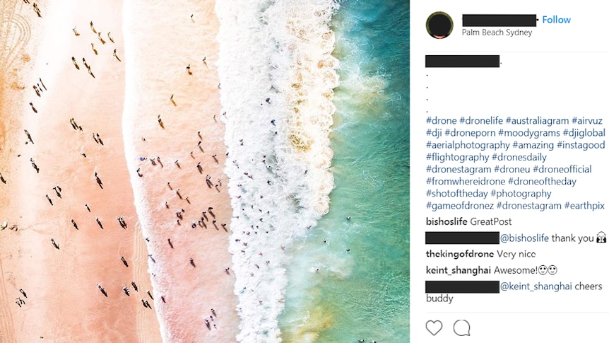 Aerial view of people in the waves and on the sand at a beach.