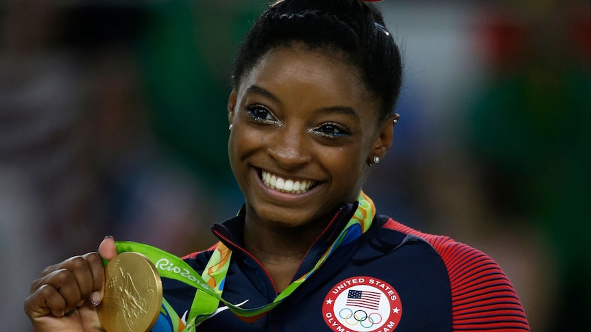 Simone Biles with her gold medal from the floor