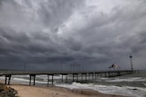 Dark grey clouds in the sky above Brighton jetty