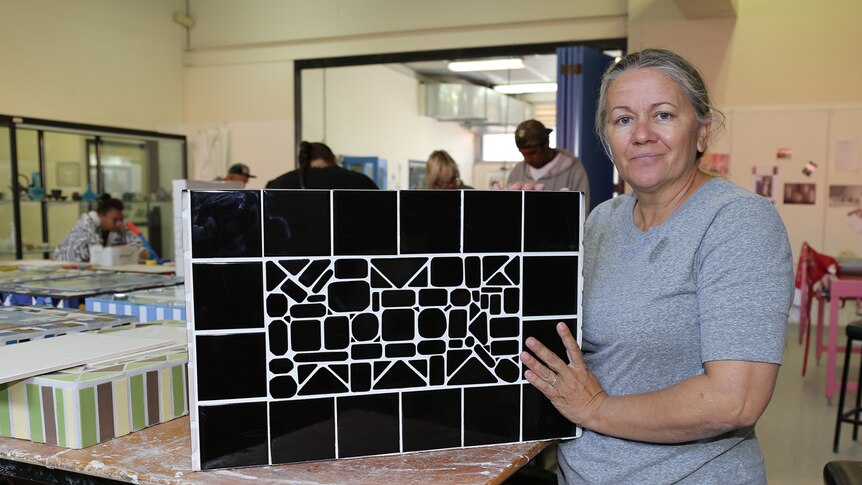 Sonya Breckenridge shows the mosaic on the back of a headstone she made for her father-in-law