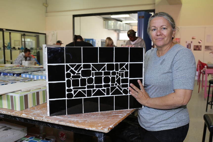 Sonya Breckenridge shows the mosaic on the back of a headstone she made for her father-in-law
