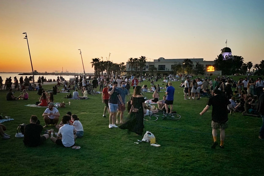 Large groups gathered at St Kilda beach for sunset.