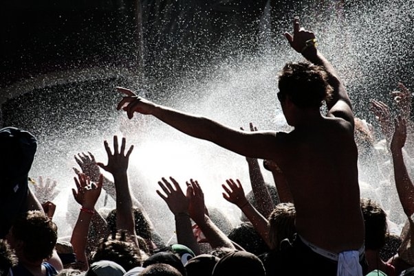 Concert goers enjoy a water jet.