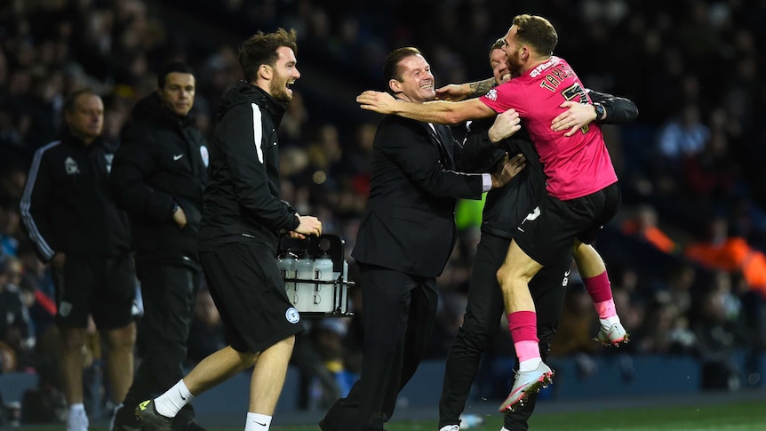 Peterborough's Jon Taylor (1st R) celebrates his FA Cup equaliser against West Brom.