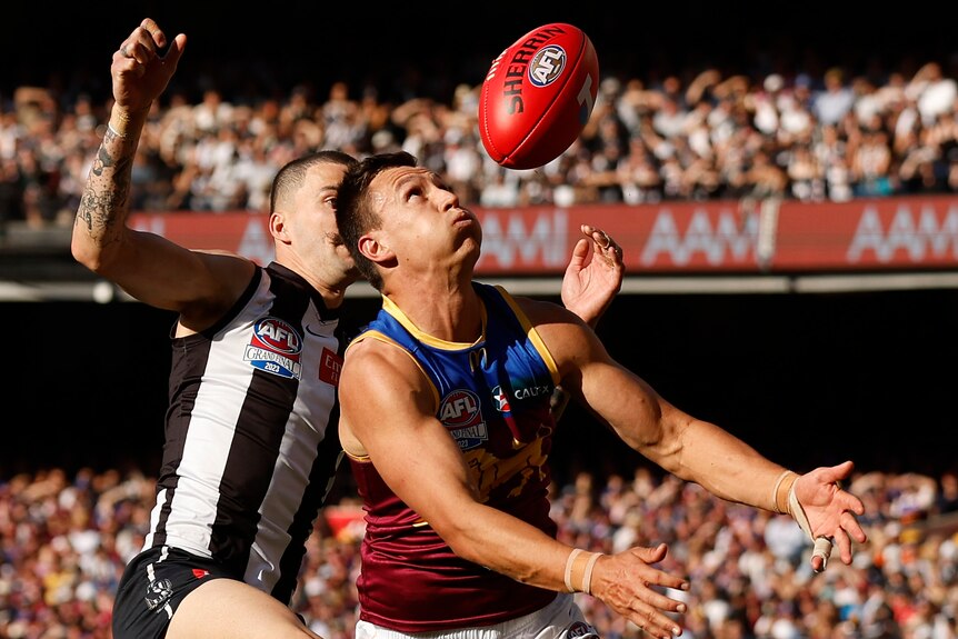 A Lions AFL player marks the ball against the Magpies in the grand final.