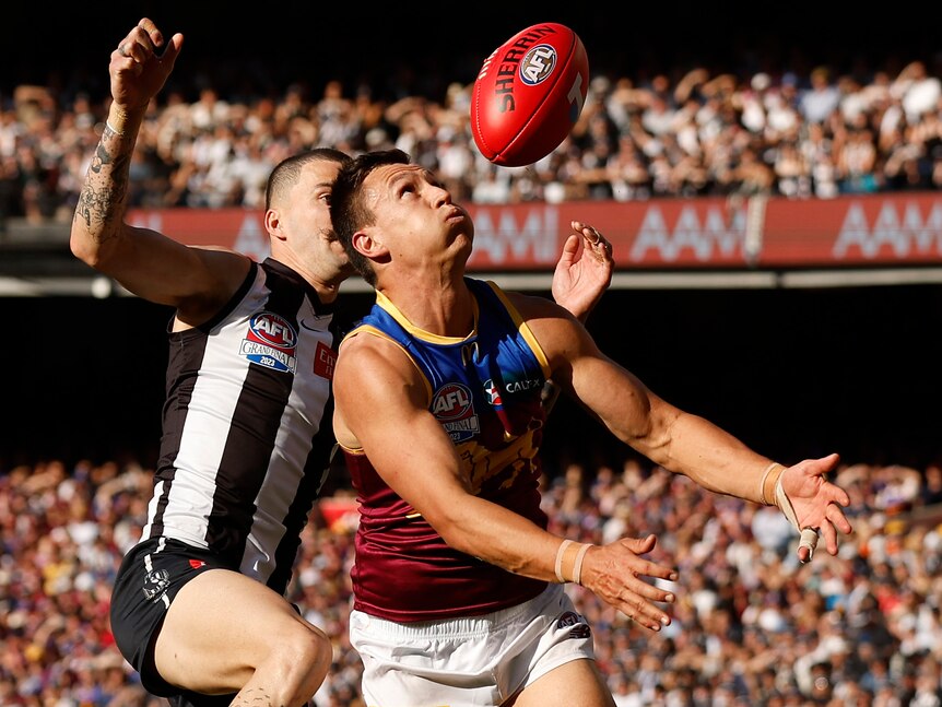 A Lions AFL player marks the ball against the Magpies in the grand final.