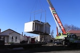 A home being moved with a crane