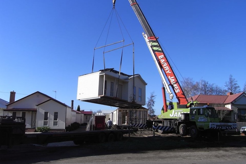 A home being moved with a crane