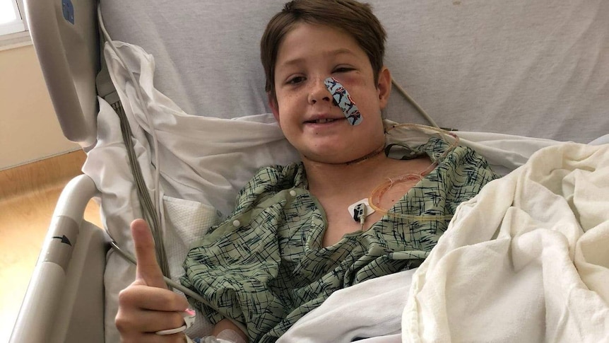 Xavier Cunningham gives a post-surgery thumbs up from his hospital bed