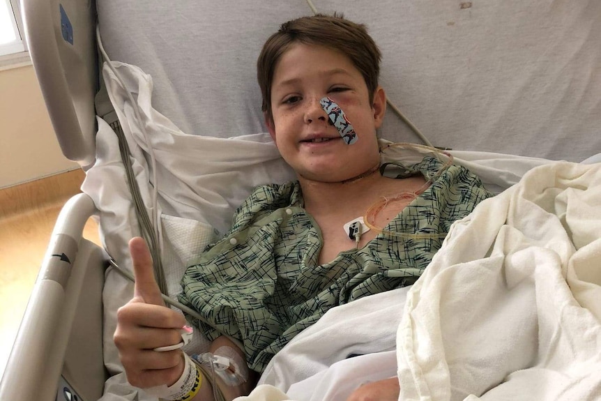 Xavier Cunningham gives a post-surgery thumbs up from his hospital bed