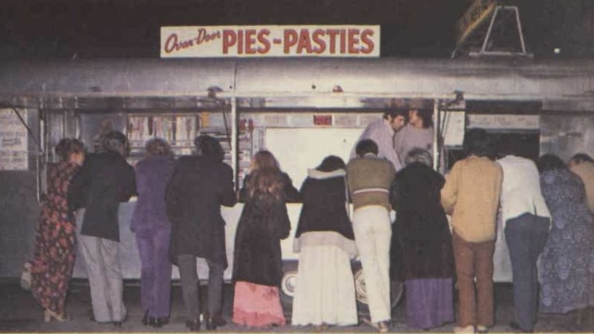 A picture from the 1970s of people lined up at a pie cart