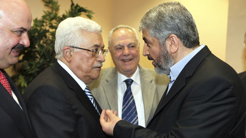 Hamas leader Khaled Meshaal (R) shakes hands and speaks with president Mahmoud Abbas (L)