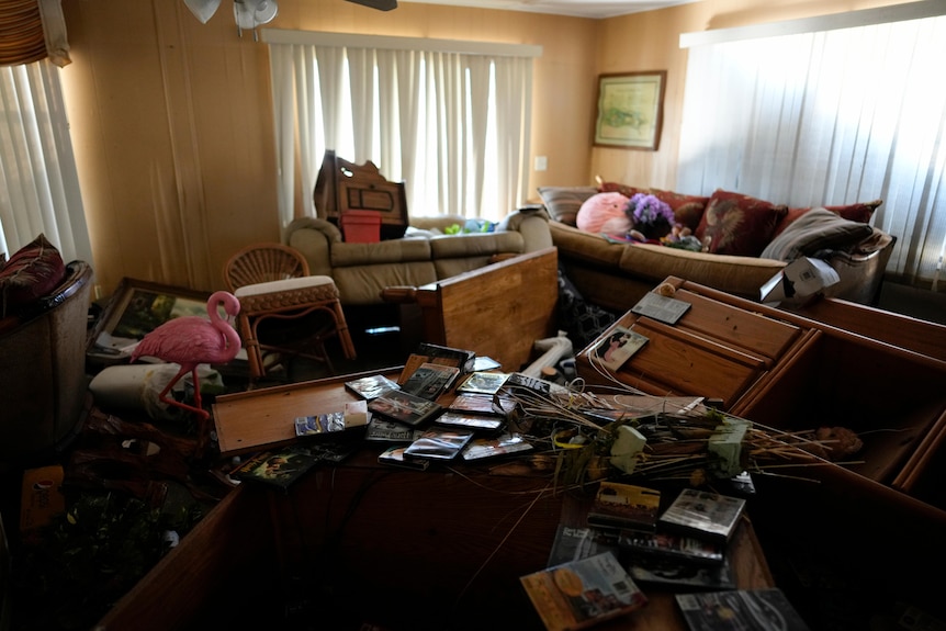 Furniture and personal items lie jumbled in the living room.