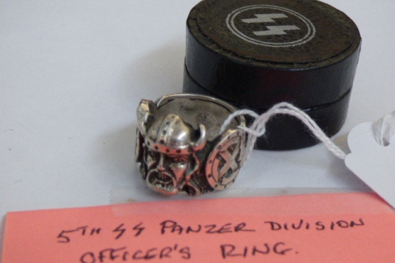 A ring with with viking-like figure on it, in an SS case