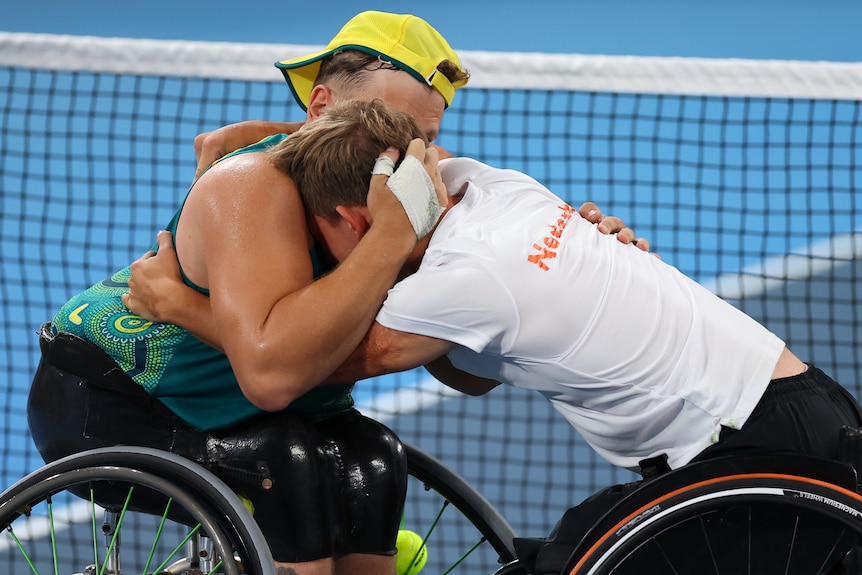 Australijczyk Dylan Alcott pociesza holenderskiego zawodnika Nilsa Finka po półfinałowym meczu tenisa na wózkach w Tokio. 