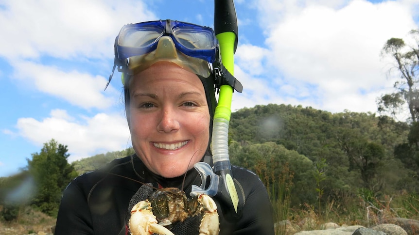 Mae Noble from The Australian National University's Fenner School of Environment and Society hold a Murray crayfish.