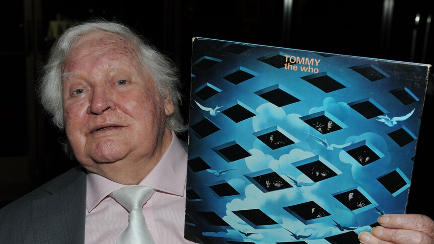 British director Ken Russell poses with the album Tommy by The Who.