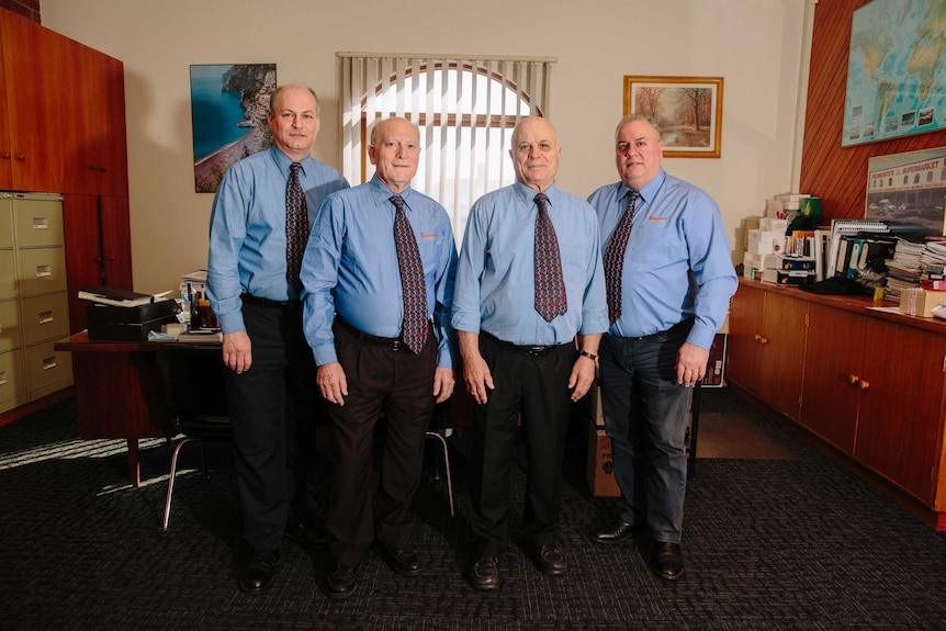 The Piedimonte men pose for a portrait in the supermarket office.