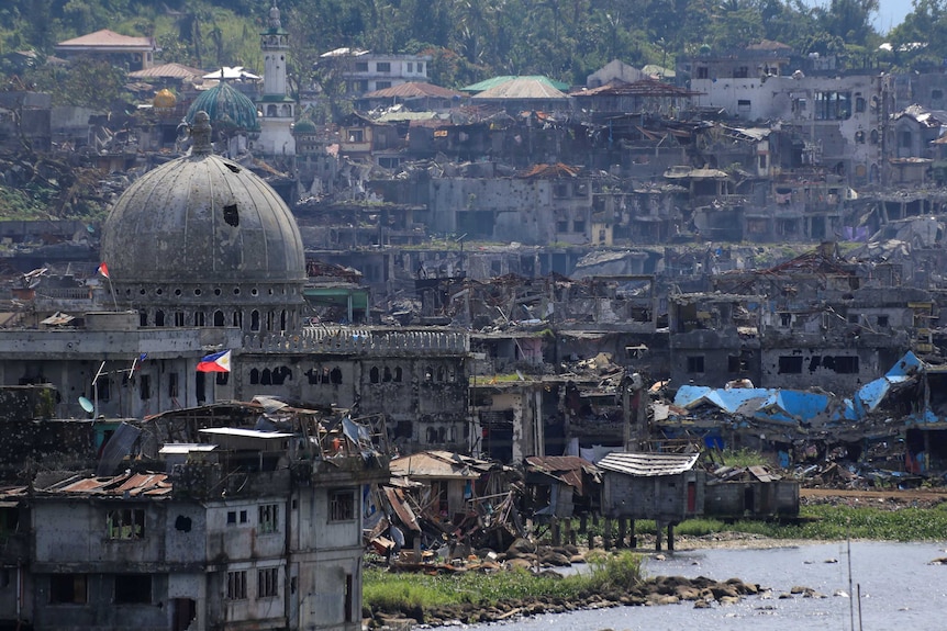 A wide shot of damaged buildings beside a mosque in Marawi city.
