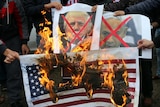 Palestinians burn posters of Benjamin Netanyahu and Donald Trump, along with a picture of the US flag