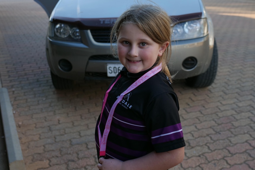 a little girl smiling in her school uniform