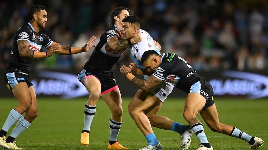 Gold Coast Titans' David Fifita is tackled by Cronulla Sharks players.