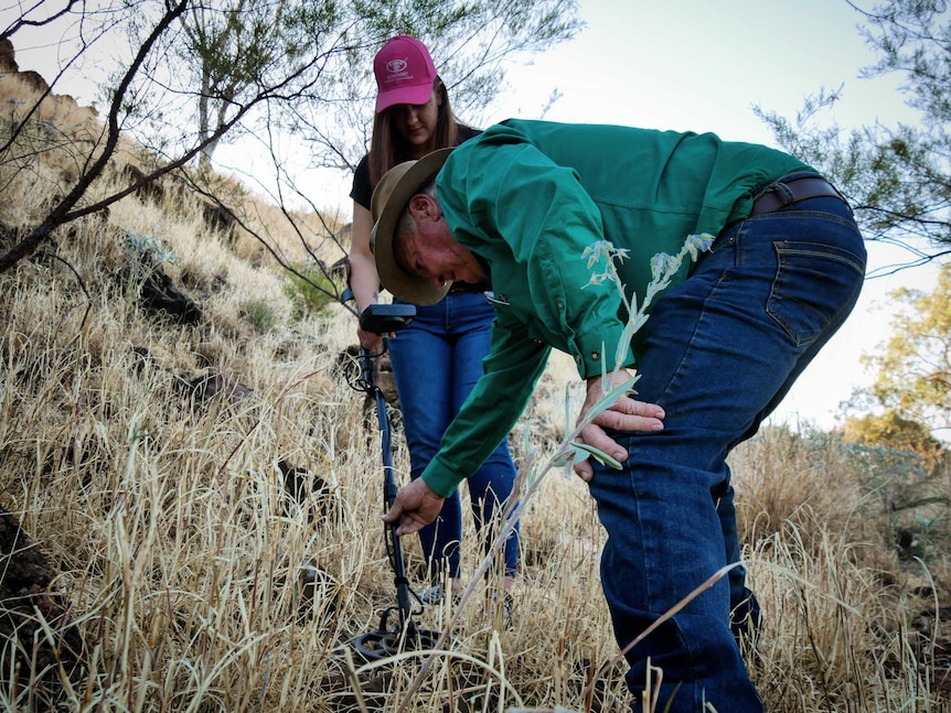 man and woman with metal detector