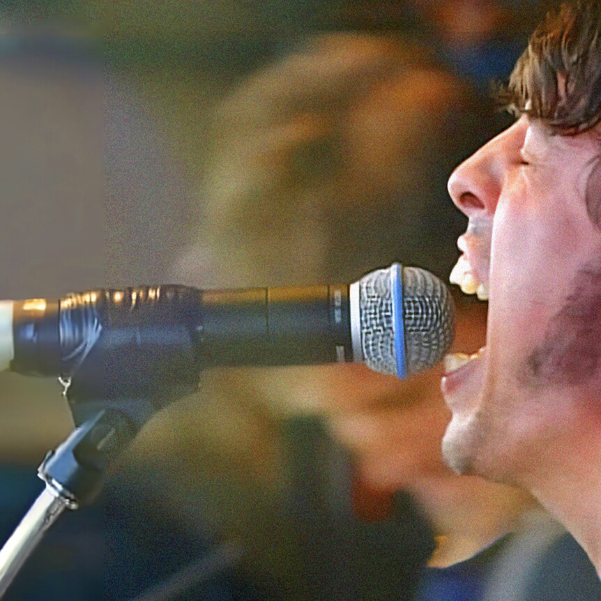Dave Grohl sings into a microphone onstage at Big Day Out in 2000