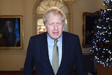 Boris Johnson entering Number 10 Downing Street walking past a Christmas tree