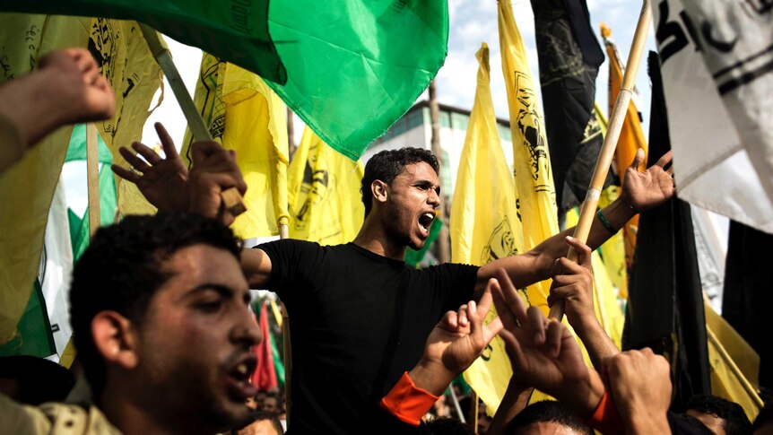 Palestinians wave Fatah and Hamas flags during ceasefire celebrations.