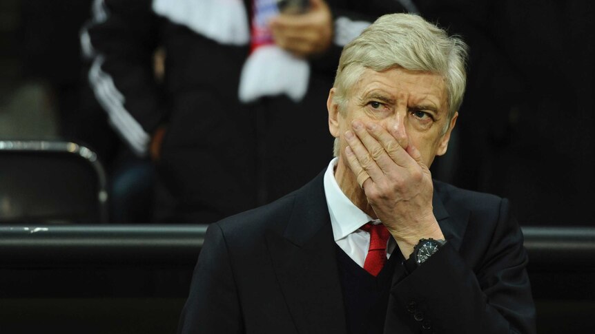 Arsenal coach Arsene Wenger covers his face during match against Bayern Munich