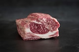 A close-up of a lamb scotch fillet marbled with fat.
