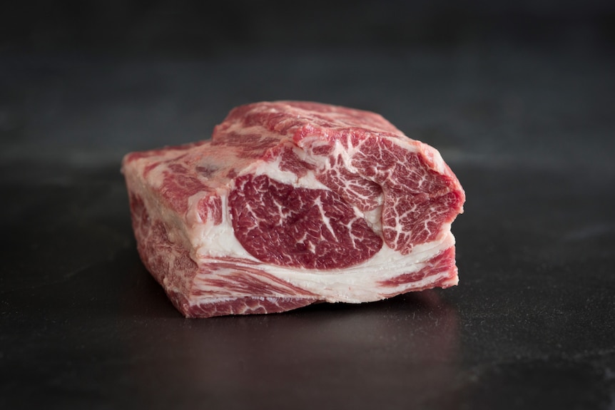 A close-up of a lamb scotch fillet marbled with fat.