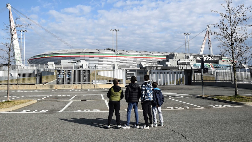 Boys look at the closed Juventus Stadium, after the team's match against Inter Milan was postponed.