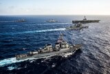 Ships from the US and Indian navies, and Japan Maritime Self-Defense Force transit in formation.