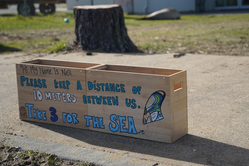 A makeshift sign and barrier placed in front of a seal asks people to keep their distance