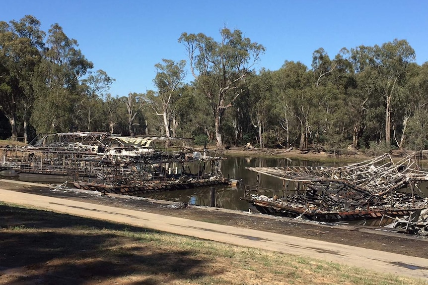 The burned-out remains of several houseboats still afloat on the river.
