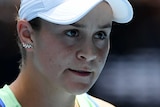 Ash Barty clenches her fist and looks sternly off camera