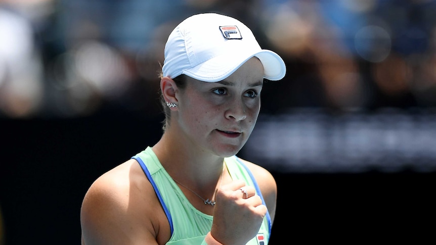 Ash Barty clenches her fist and looks sternly off camera