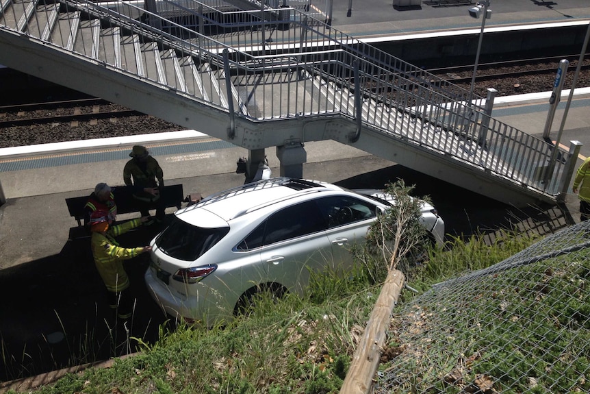 A car is wedged between stairs and an embankment on the platform of Croydon train station