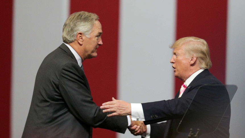 Senator Luther Strange and US President Donald Trump shake hands at a rally in Alabama.