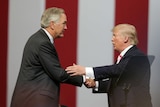Senator Luther Strange and US President Donald Trump shake hands at a rally in Alabama.