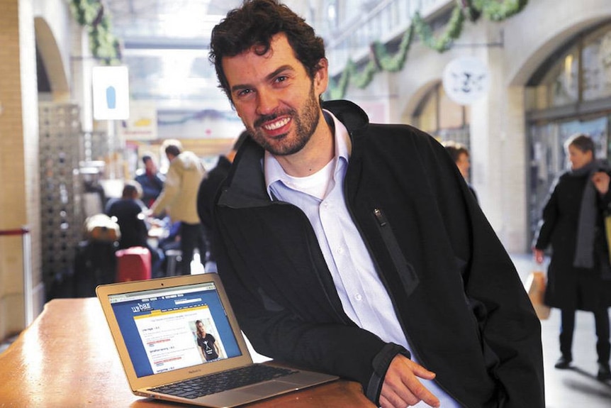 Urban Dictionary founder Aaron Peckham leans next to laptop.